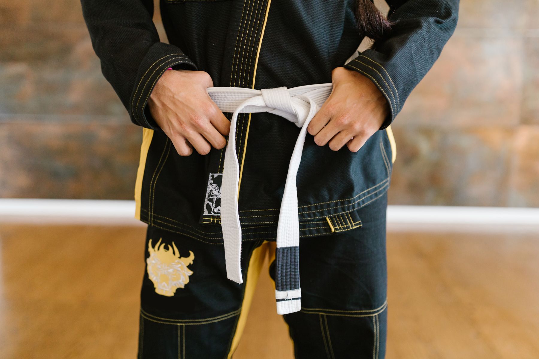 Student tying a Brazilian Jiu-Jitsu belt
